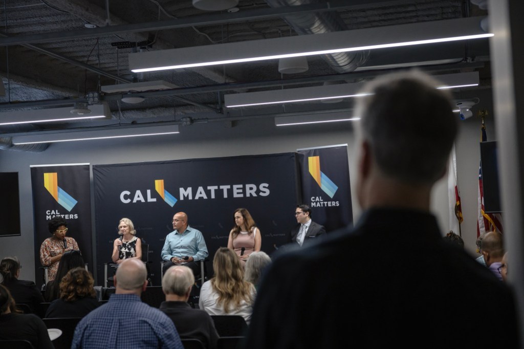 People on a panel speak as attendees listen at the CalMatters studio in Sacramento.